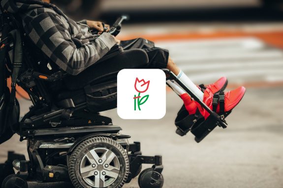 logo PFRON, w tle osoba oglądająca smartfona na wózku elektrycznym.