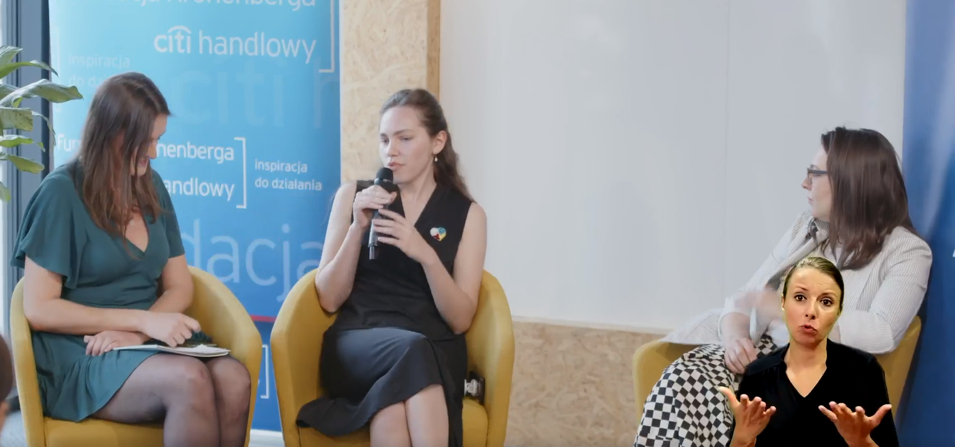 Zdjęcie przedstawia trzy kobiety prowadzące dyskusję panelową przy mikrofonie.