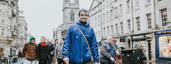 Zdjęcie jednego z przewodników Invisible Cities na tle ruchliwej ulicy Edydburga.
