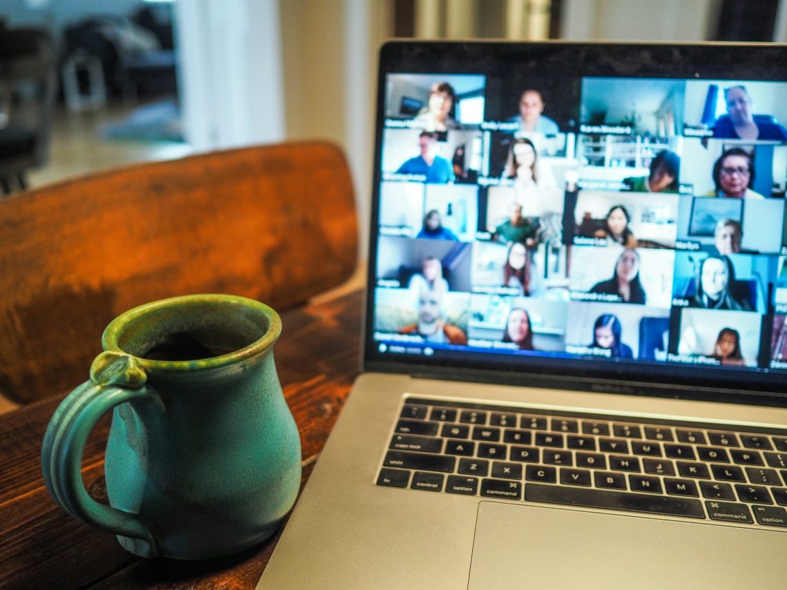 Otwarty laptop. Na ekranie widać osoby uczestniczące w webinarze
