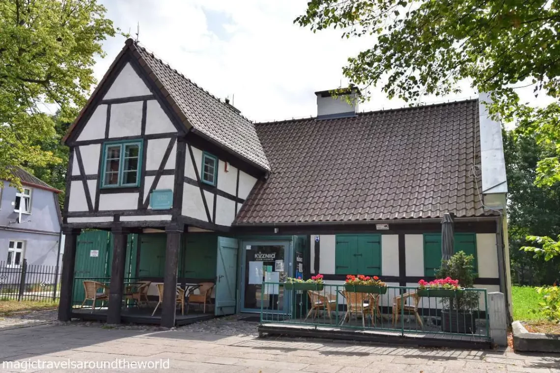 domek kawiarni o szachulcowych ścianach i morskozielonych okiennicach i framugach okien