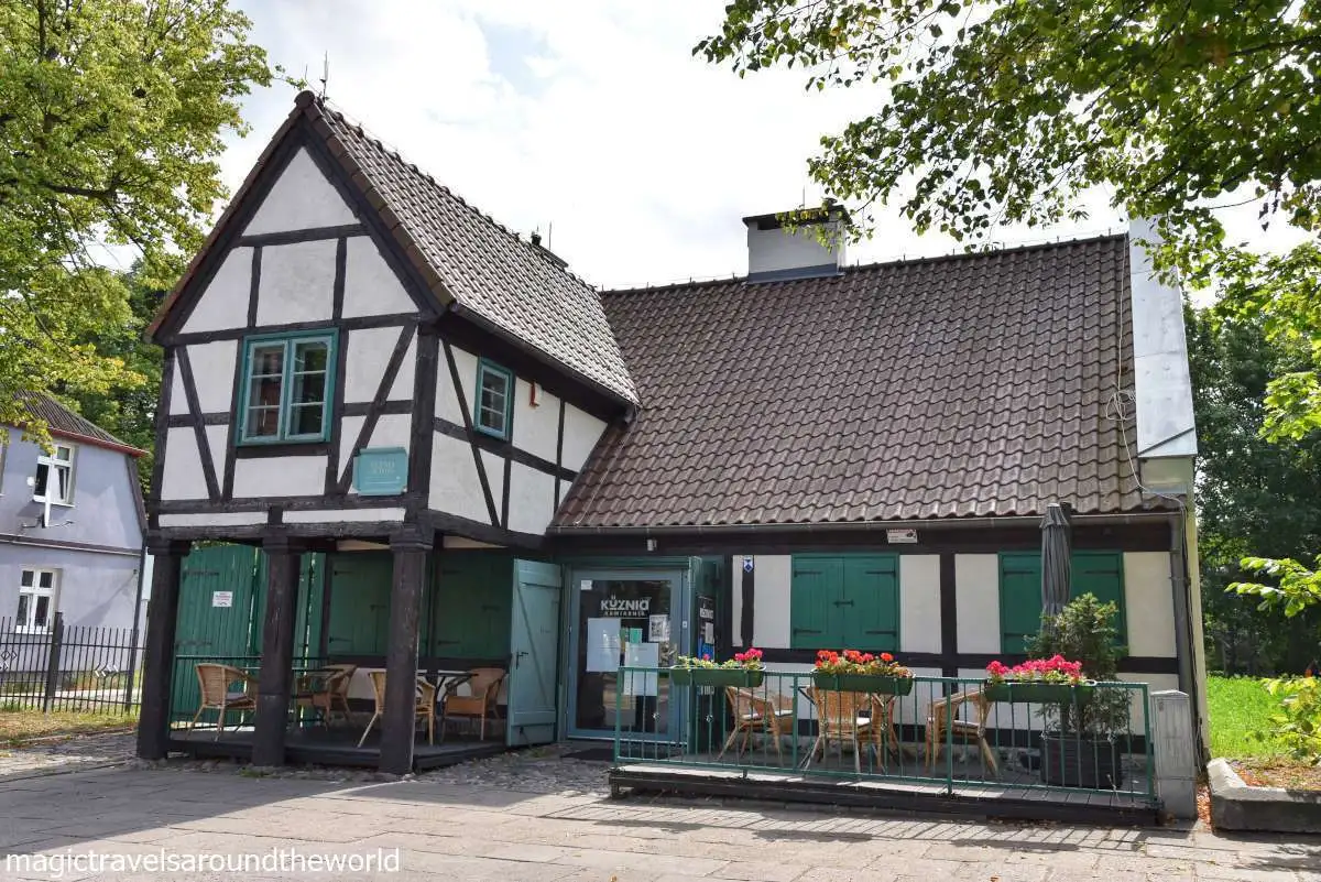 domek kawiarni o szachulcowych ścianach i morskozielonych okiennicach i framugach okien