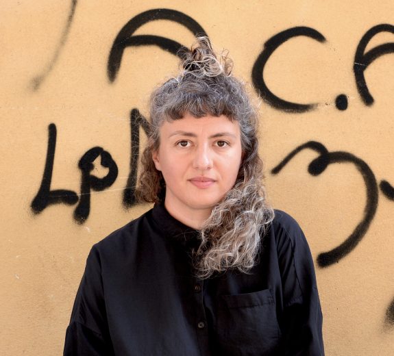 Kobieta stojąca na tle ściany z grafitti